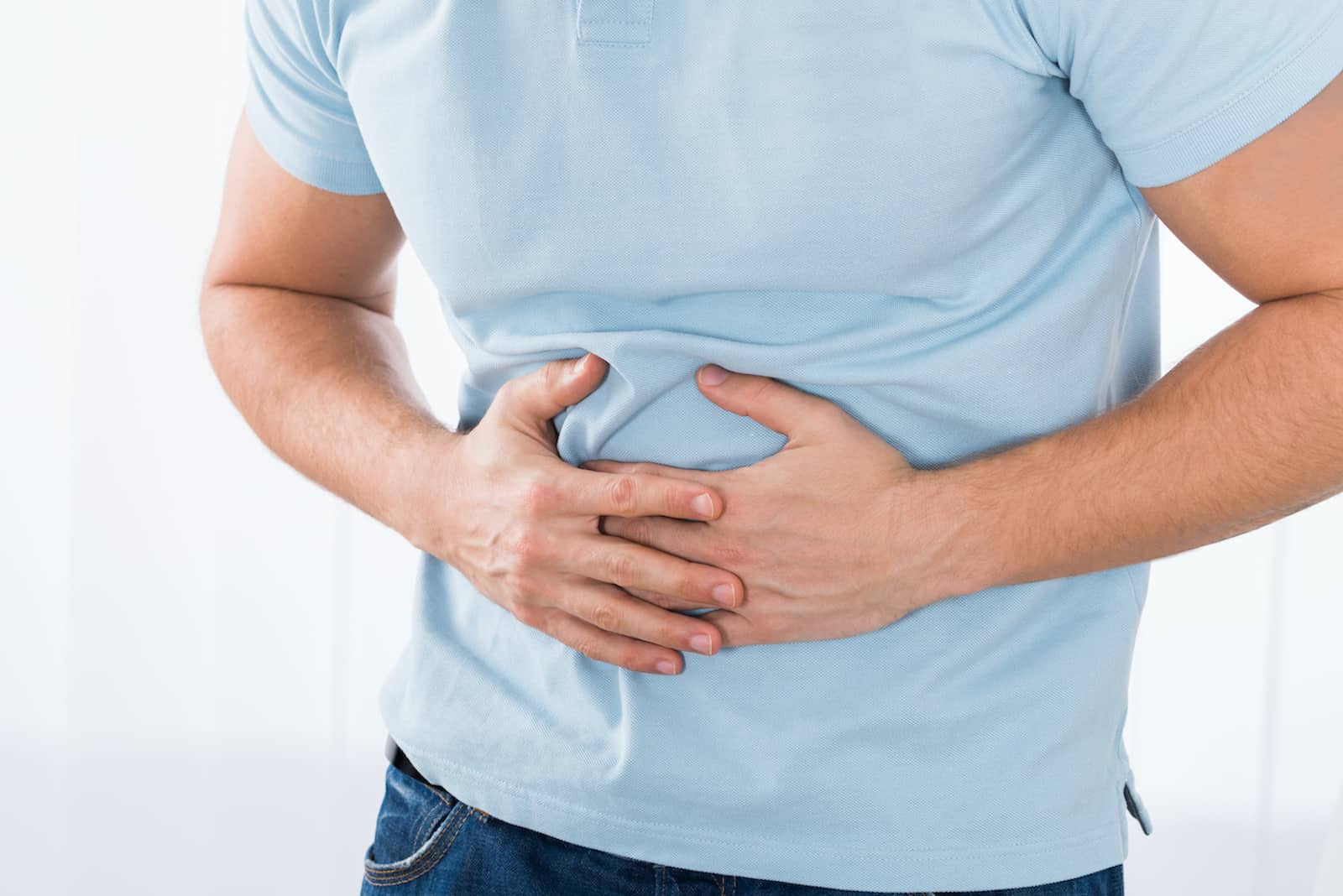 probiotics for bloating: man holding his stomach