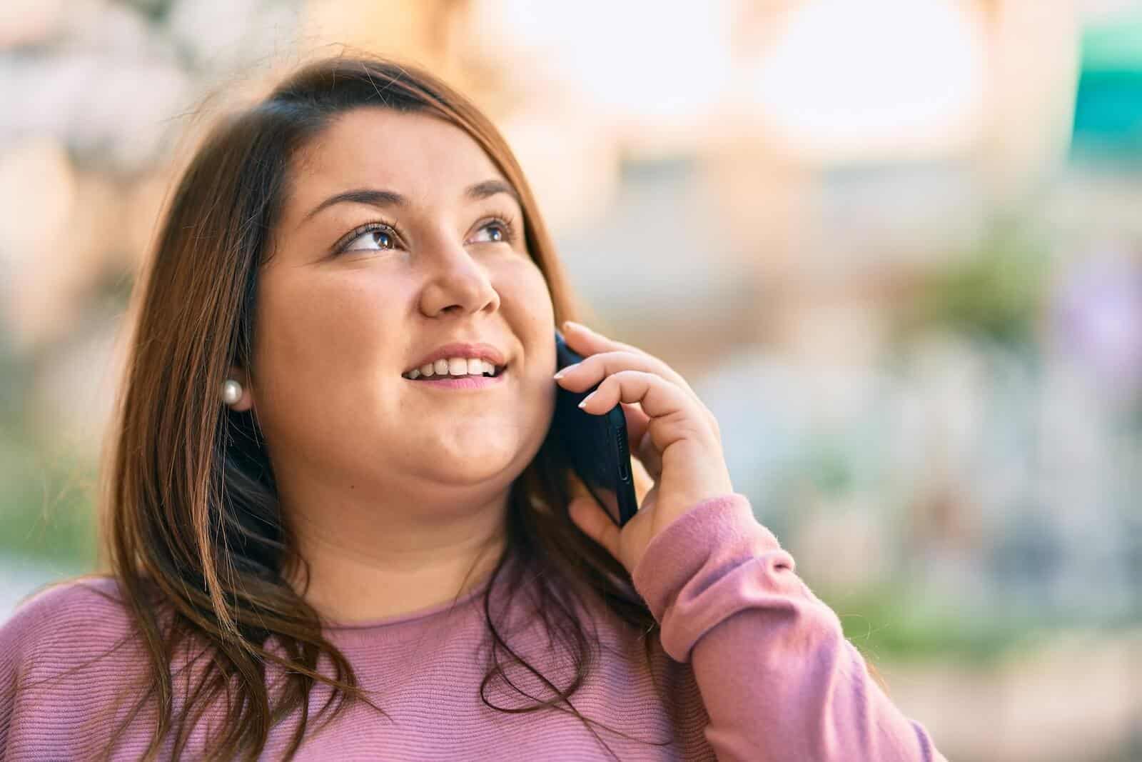 PCOS supplements: smiling woman on her phone